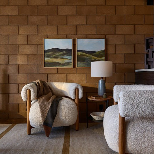 Modern living space with boucle lounge chairs, layered pillows, a soft throw blanket, and framed wall art, styled as part of Denver Modern’s Pillows & Throws collection.