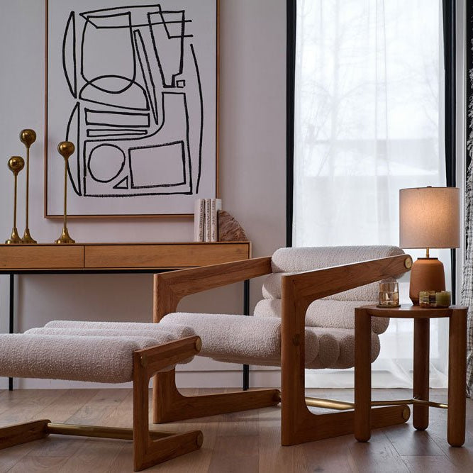 Modern Denver Modern lounge chair and ottoman set beside a wooden side table, styled with a lamp and candle, in a bright contemporary living space with abstract wall art.