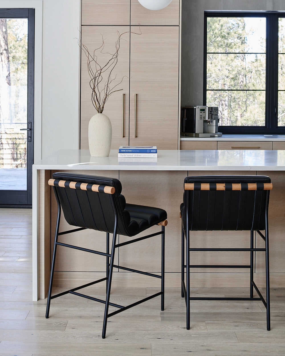 Elegant black leather Vail Counter Stools complement a modern kitchen's neutral palette and clean lines.
