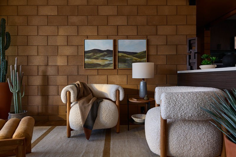 Modern living space with boucle lounge chairs, layered pillows, a soft throw blanket, and framed wall art, styled as part of Denver Modern’s Pillows & Throws collection.