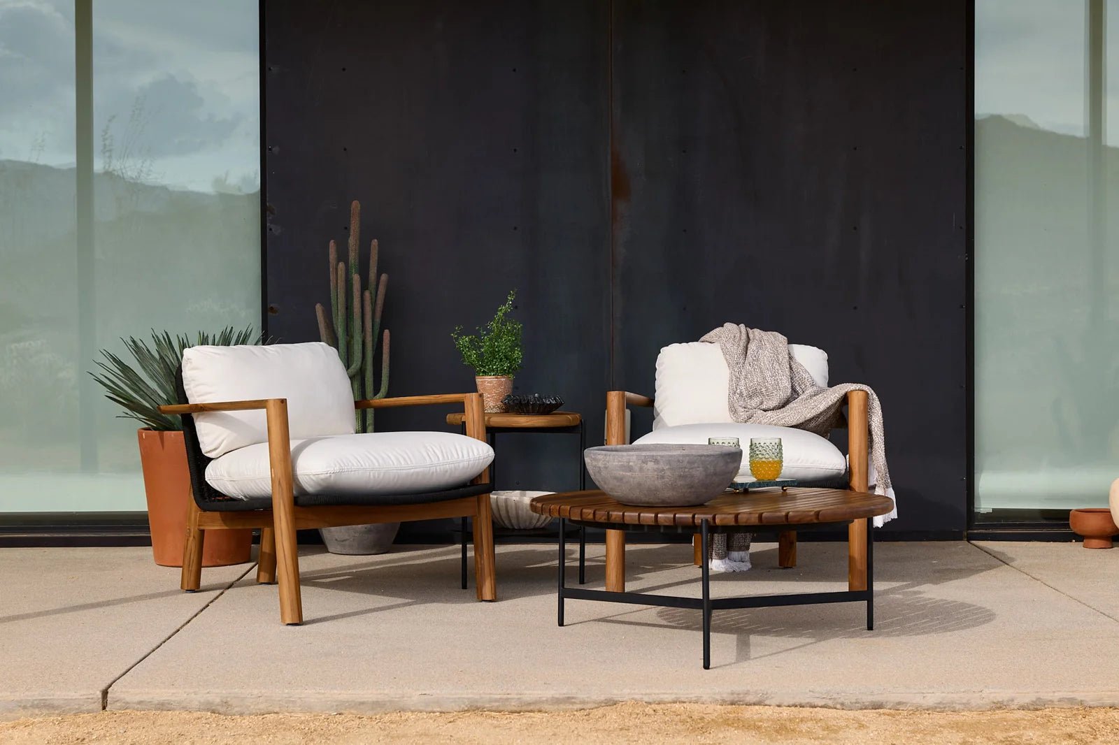 Modern outdoor lounge chairs with white cushions and table, styled for Denver Modern’s Closeouts & Clearance collection.