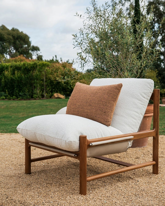 a chair with a pillow on sand