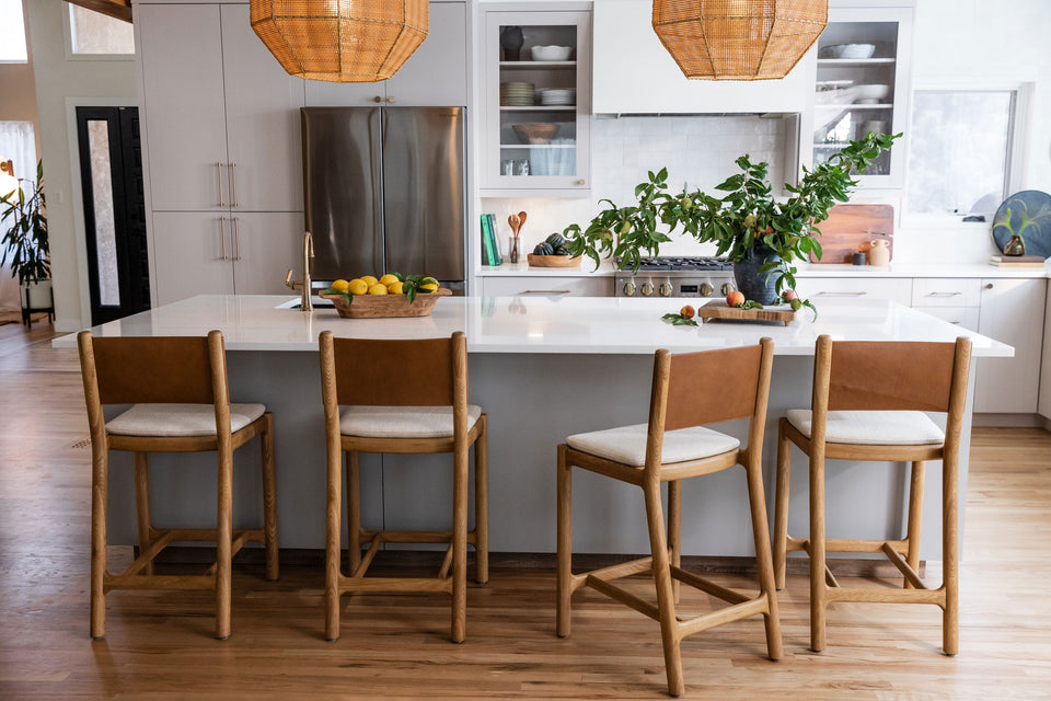 a kitchen with a white island and chairs