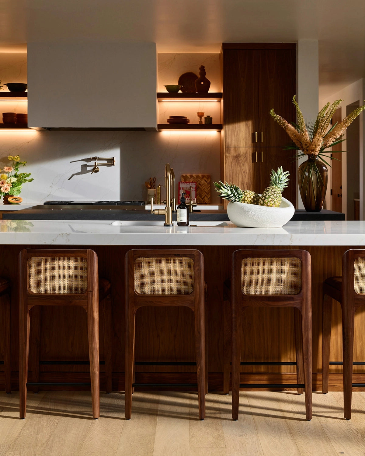 Canyon Counter Stools in walnut with woven cane backs styled at a modern kitchen island