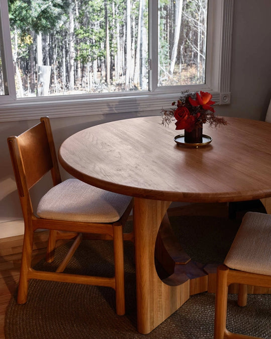 a table with chairs and a vase of flowers