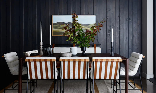 a dining table with chairs and a vase of flowers