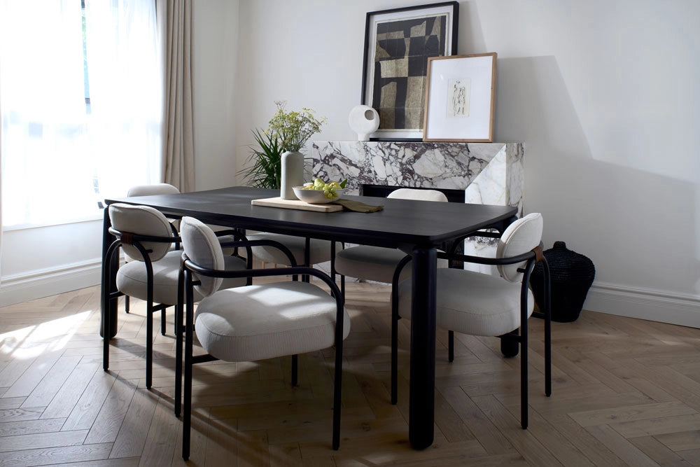 Dining room with a black table and Arches Dining Chairs in Cream Corduroy, light wood flooring, and framed artwork on the wall.