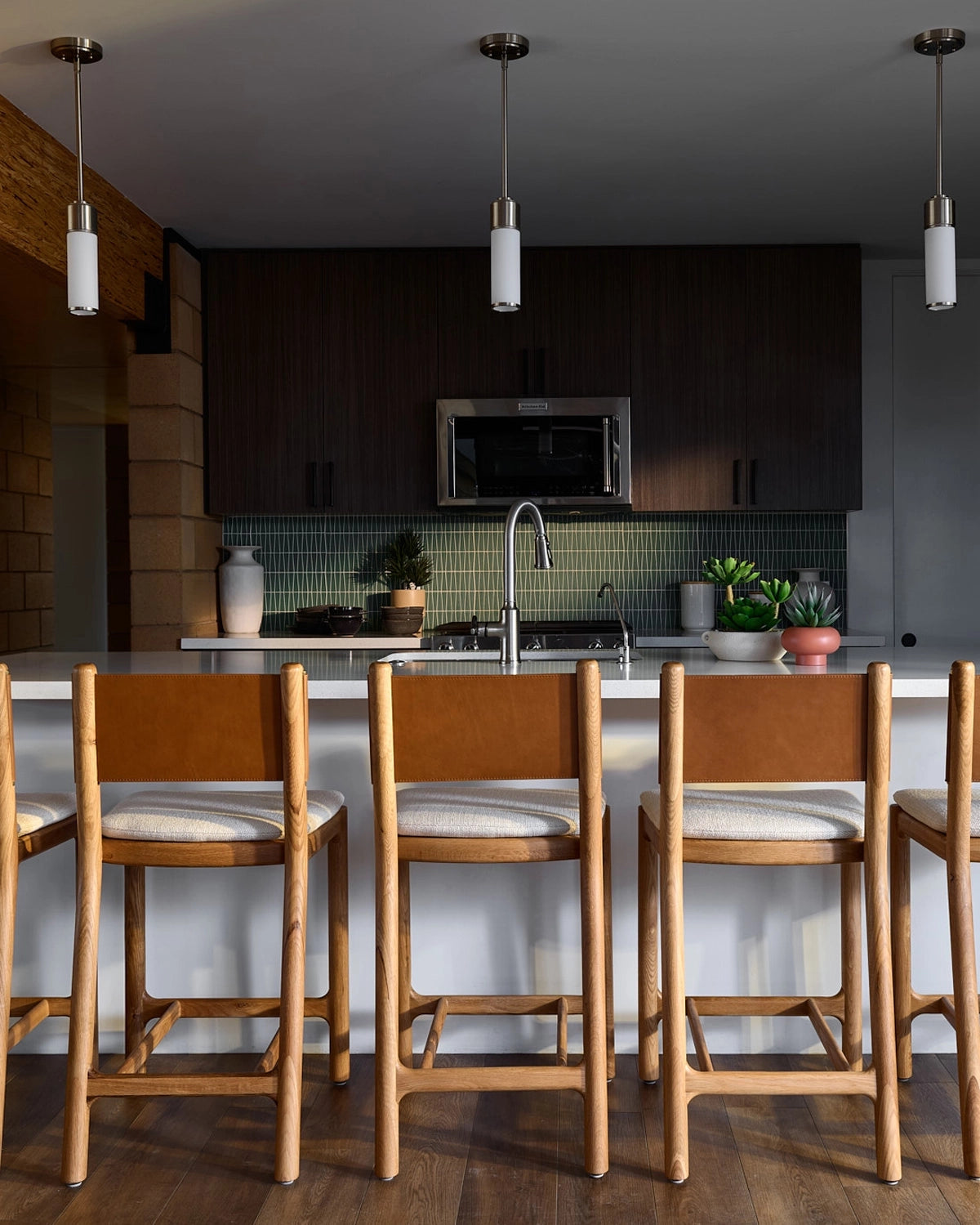 Modern kitchen with wooden Avon Counter Stools and a white countertop.