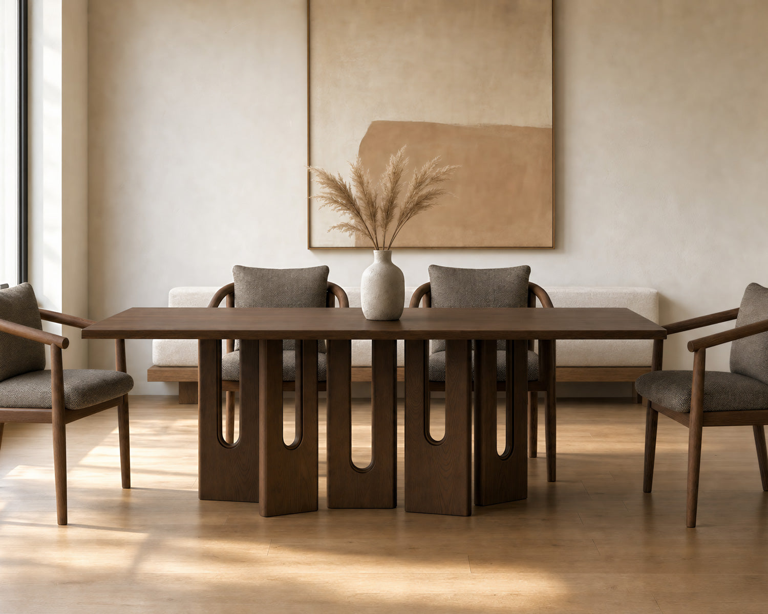 A modern dining table with a dark wood top and sculptural cutout legs, surrounded by four upholstered dining chairs in a warm, minimalist dining room setting.