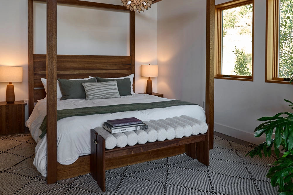 Bedroom with wooden four-poster bed, nightstands, and the Jasper Bench.
