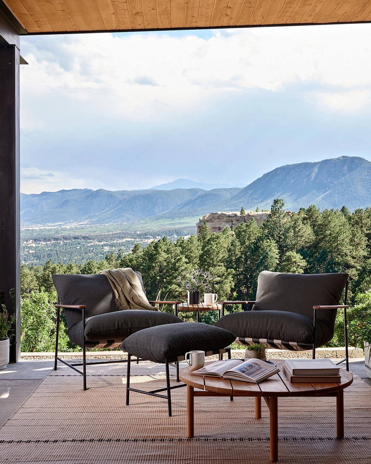 Outdoor Vail Lounge chairs styled on a covered patio with mountain views, paired with matching ottoman and modern outdoor accents
