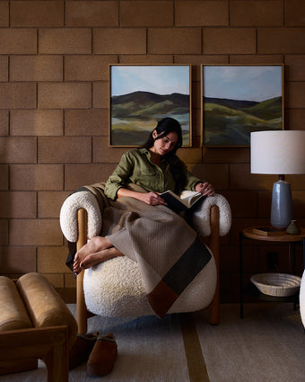 a woman sitting in a chair reading a book