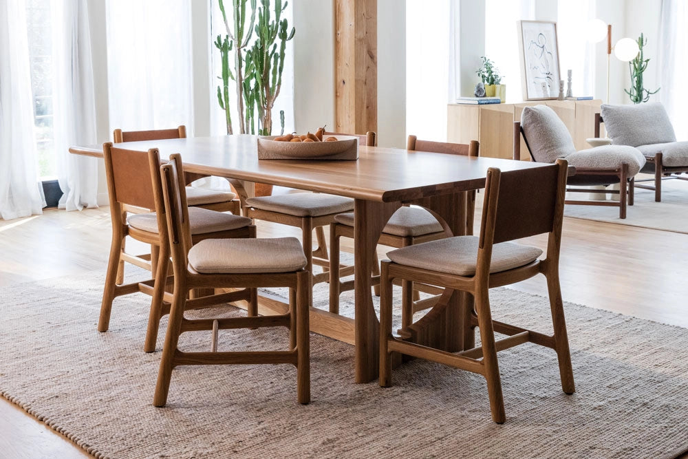 Summit Dining Table with Avon Dining Chairs in a bright room with plants and furniture.