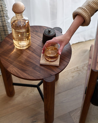 a hand holding a glass of liquid on a table