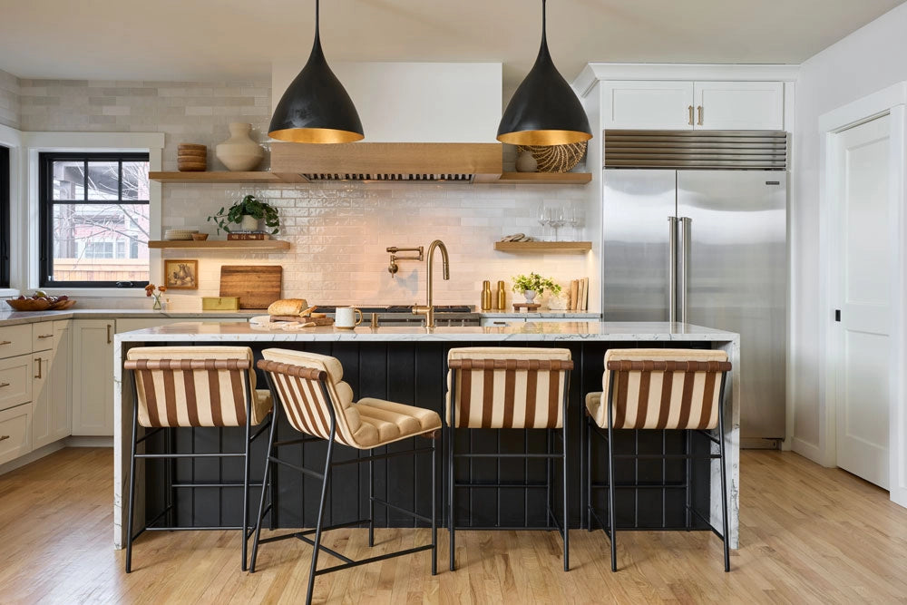 Modern kitchen with island and Vail Counter & Bar Stools, featuring stainless steel appliances and wooden flooring.