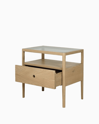 a wooden nightstand with a glass top